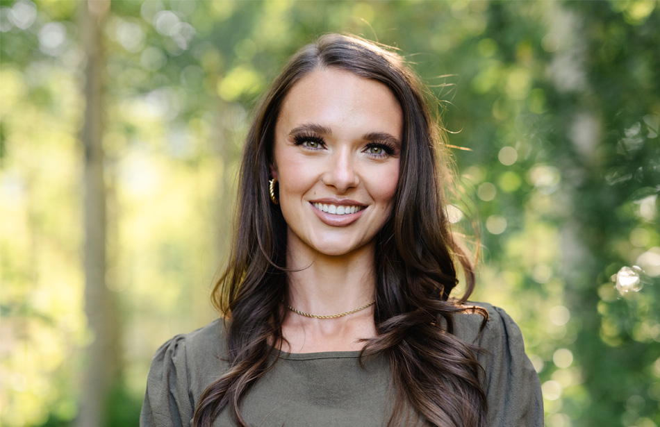 Taylor Ann, someone with NMOSD, smiling with trees in the background.