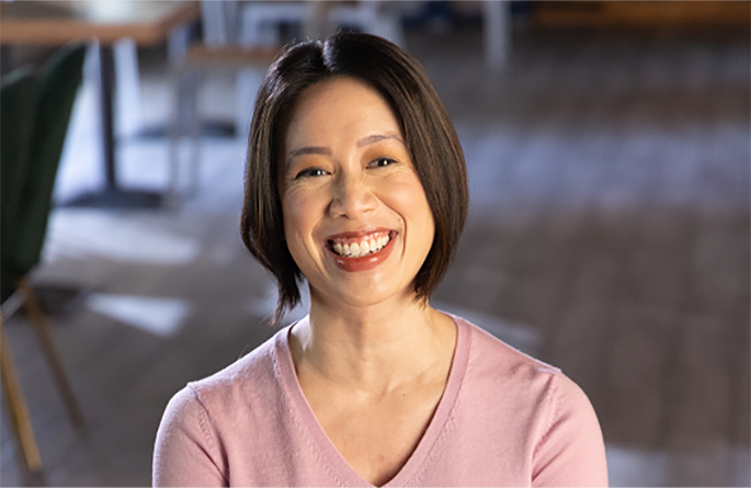 Taylor Ann, someone with NMOSD, smiling with trees in the background.